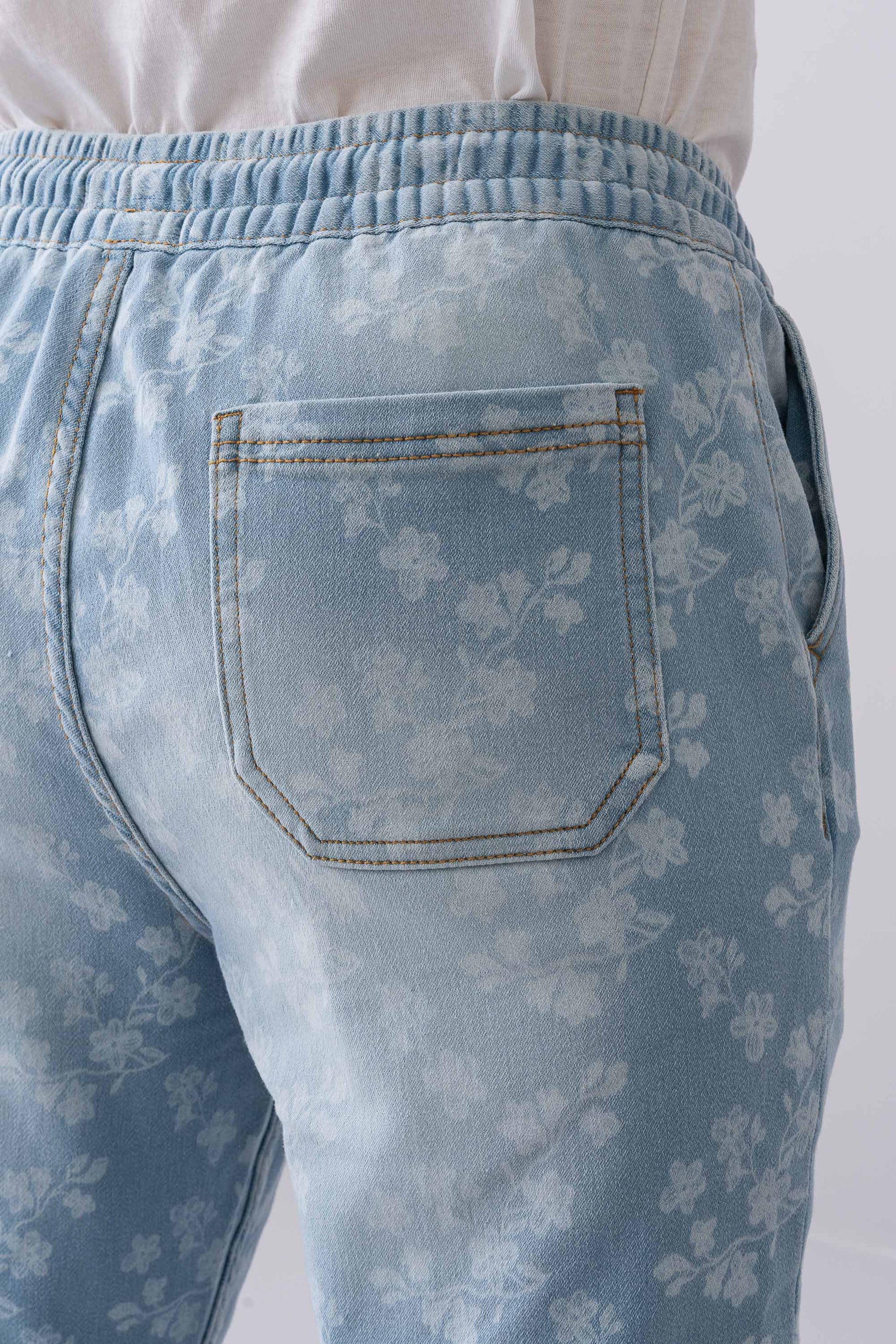 Close-up of the back pocket on Fashnica women's light blue floral print stretch denim jeans.